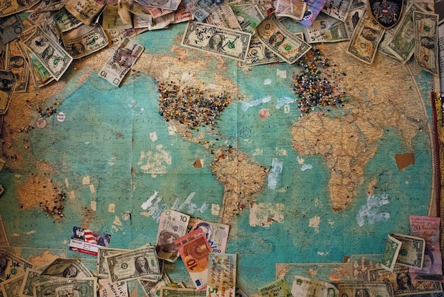 ピンや世界中のお金を置いた世界地図